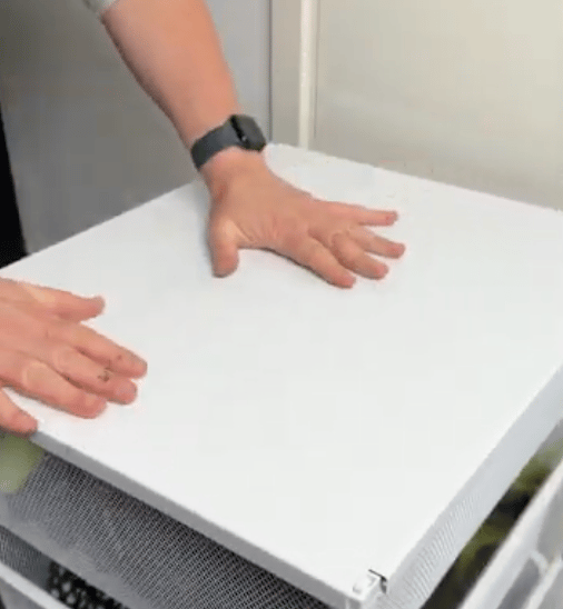 Hands on a white surface, one with a smartwatch.