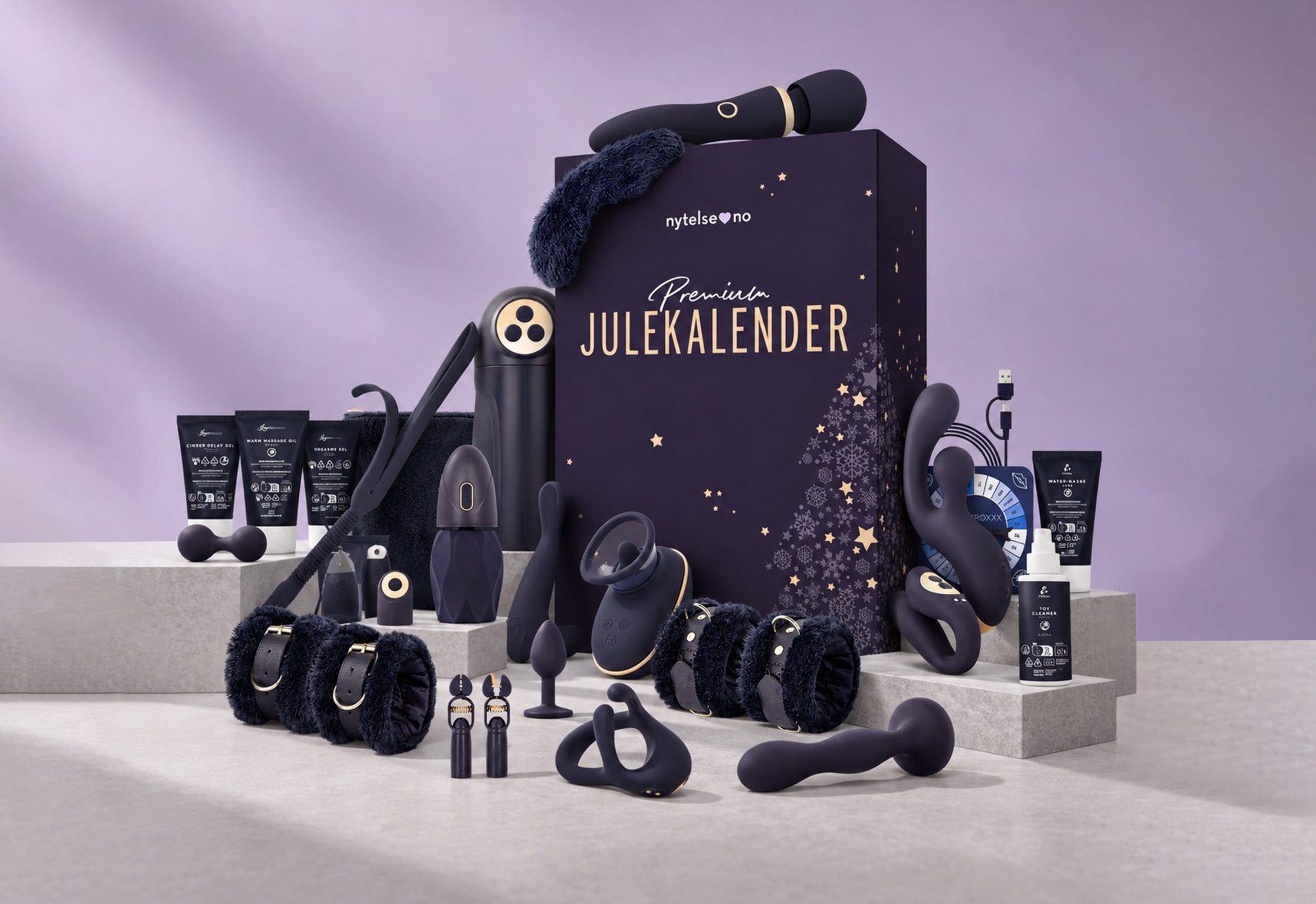 An assortment of dark-colored adult toys, lubricants, and cuffs, arranged around a 'Premium JULEKALENDER' advent calendar.