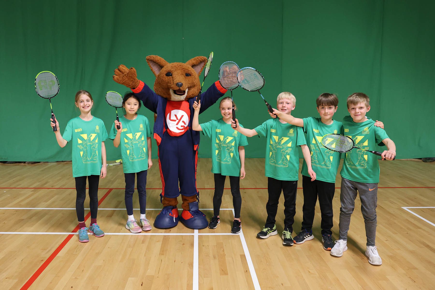 group of children with badminton rackets with LYG mascot