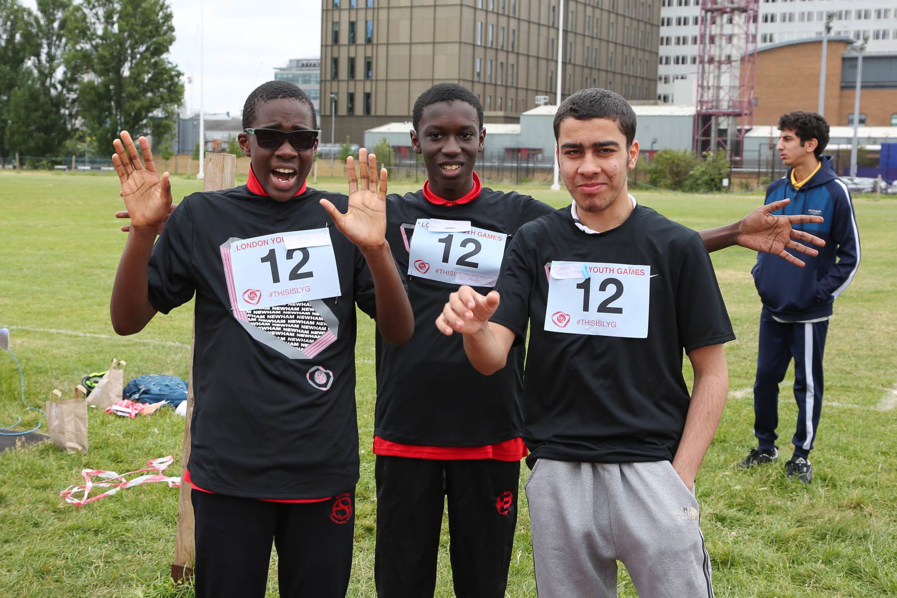 3 boys posing for a photo with hands in the air