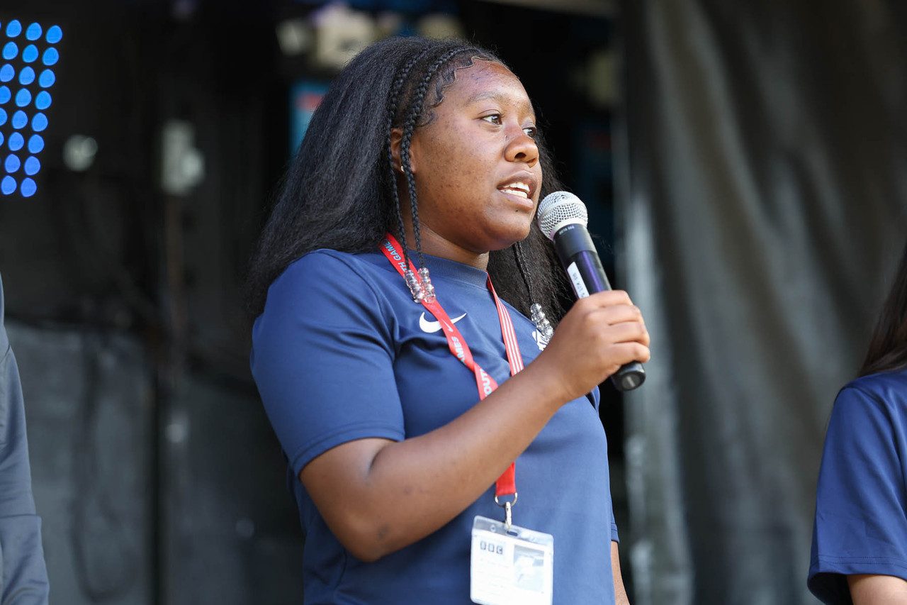 black female member of LYG33 speaks into microphone