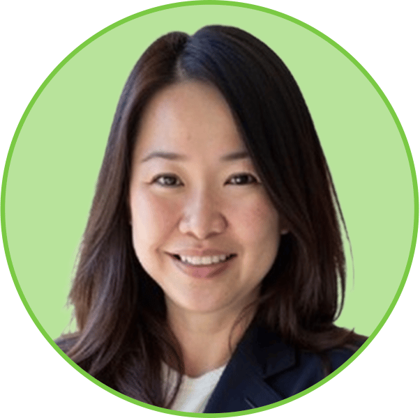 Smiling Asian woman with dark hair wearing a blazer, looking directly at the viewer.