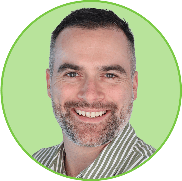 Headshot of a smiling man with a beard in a green circular frame.