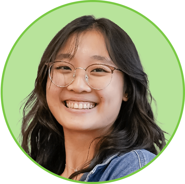 A smiling young woman with dark hair and glasses, set against a bright green circular background.