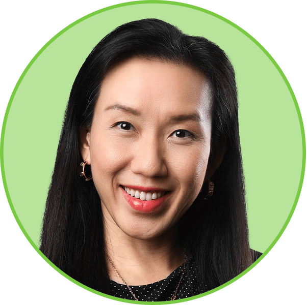 Smiling Asian woman with long dark hair in a circular frame, wearing a black top and earrings.