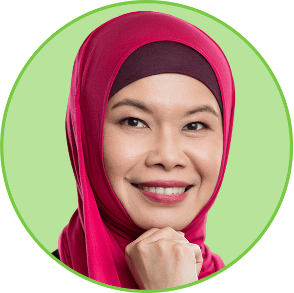 Smiling Asian woman in pink hijab, hand under chin, light green background.