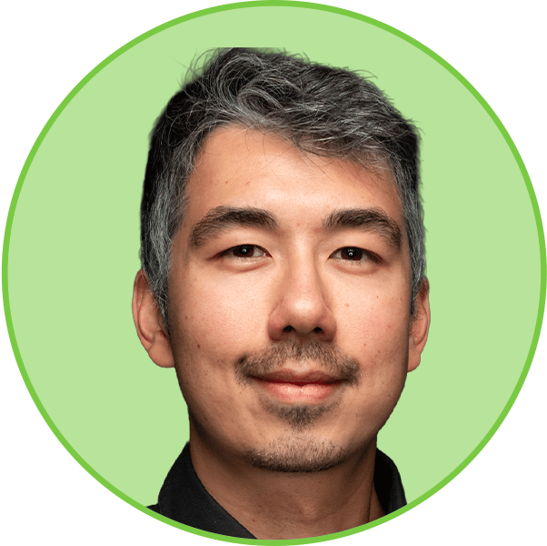 Headshot of an East Asian man with graying hair and a mustache, smiling.
