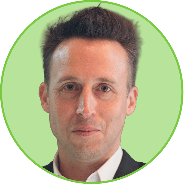 Professional headshot of a smiling man with short brown hair wearing a suit, framed in a green circle.