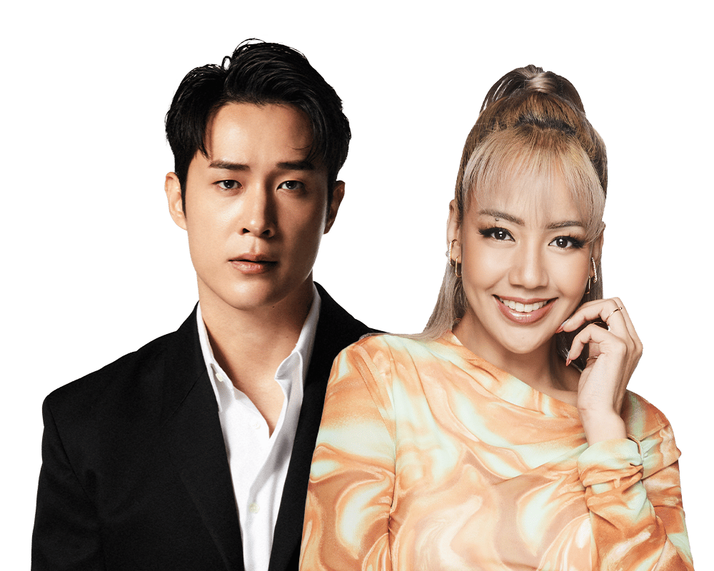 A man in a black suit and a smiling woman in an orange top stand together.