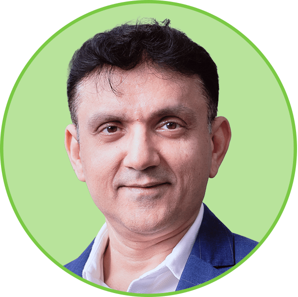 Headshot of a smiling man in a blue suit jacket against a light green background.