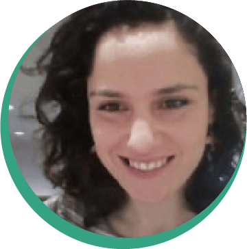 Headshot of a smiling woman with dark, curly hair.