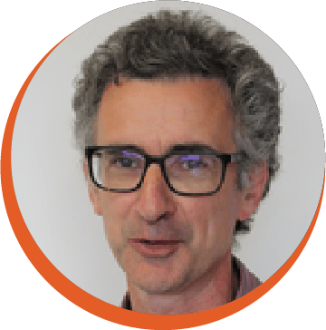 Headshot of a middle-aged man with glasses and grey, wavy hair, looking slightly to the side.