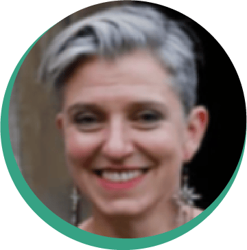 Smiling woman with short gray hair and earrings in a circular headshot.