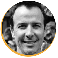 Smiling man's grayscale headshot.