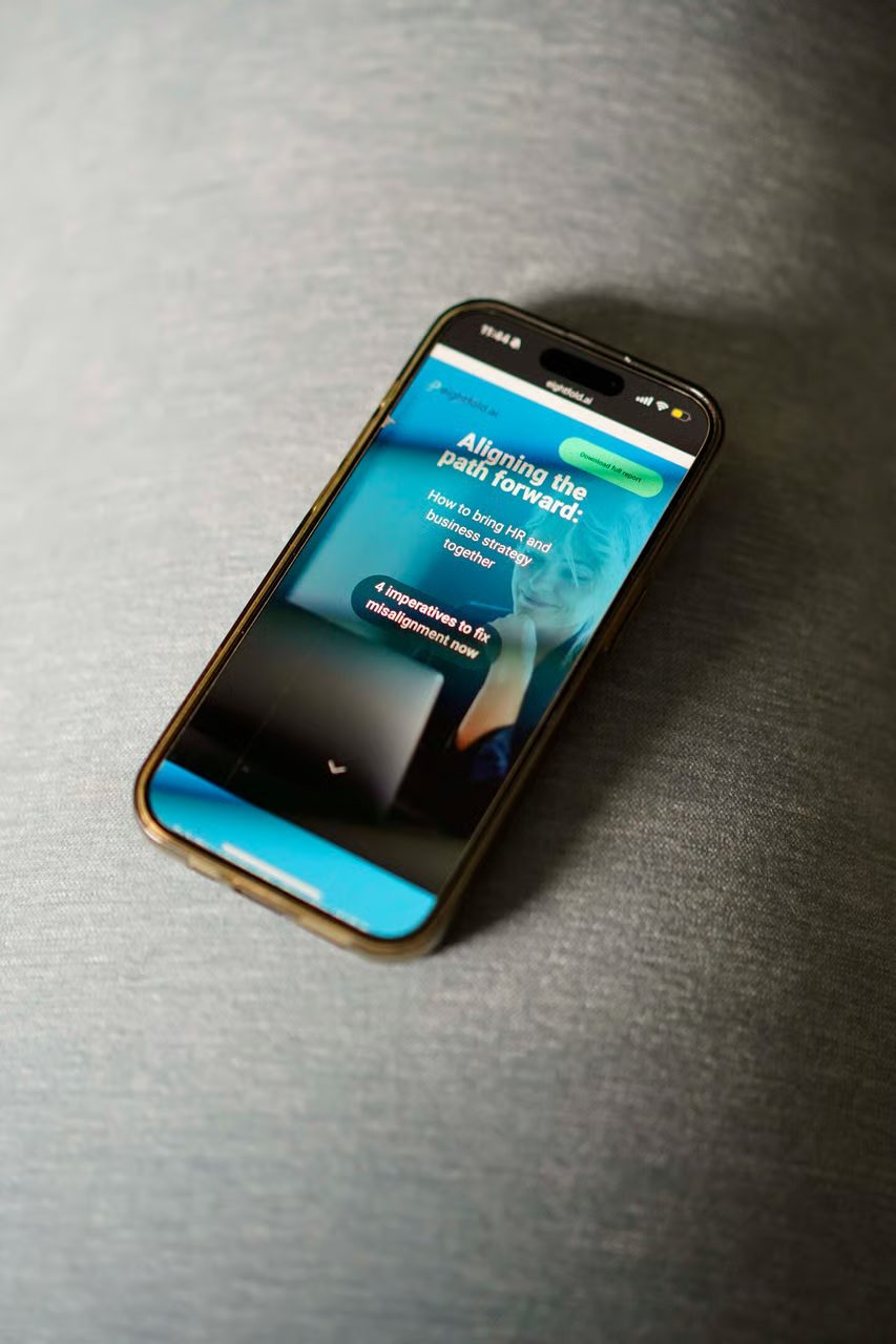 Smartphone displaying a webpage titled "Aligning the path forward: How to bring HR and business strategy together."