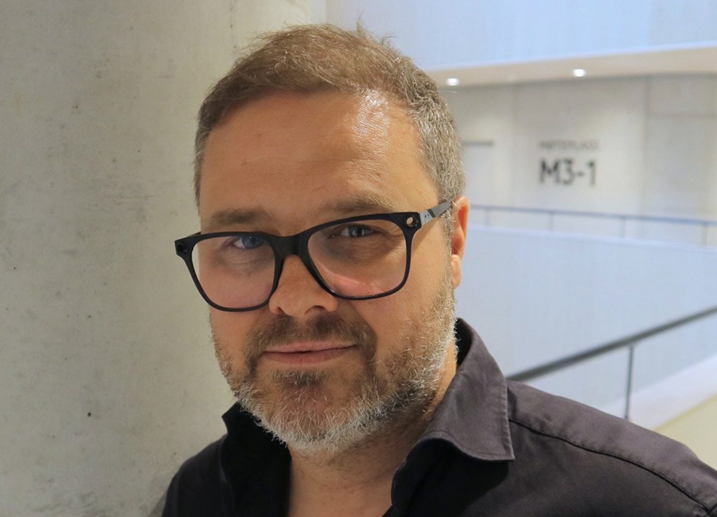 Smiling middle-aged man with glasses and beard.