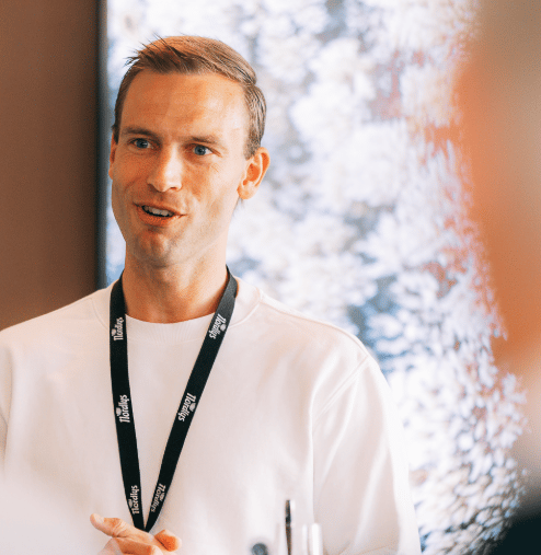 Man in white shirt and Florallys lanyard speaking.