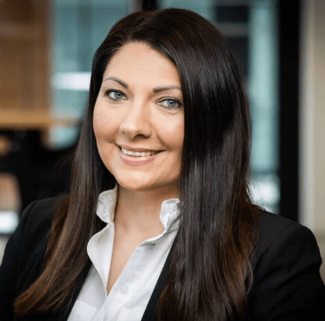 Professional headshot of a smiling woman with long dark hair.