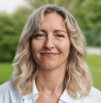 Smiling blonde woman with wavy hair.