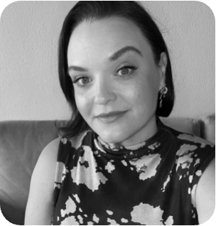 Black and white portrait of a smiling woman with dark hair and a patterned top.