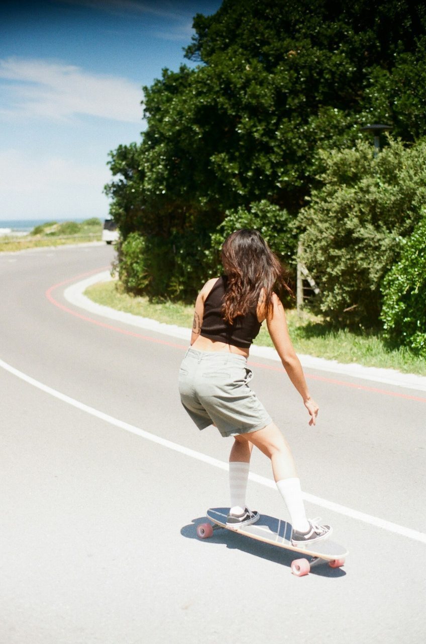 Woman, longboard and down hill for adventure on holiday.