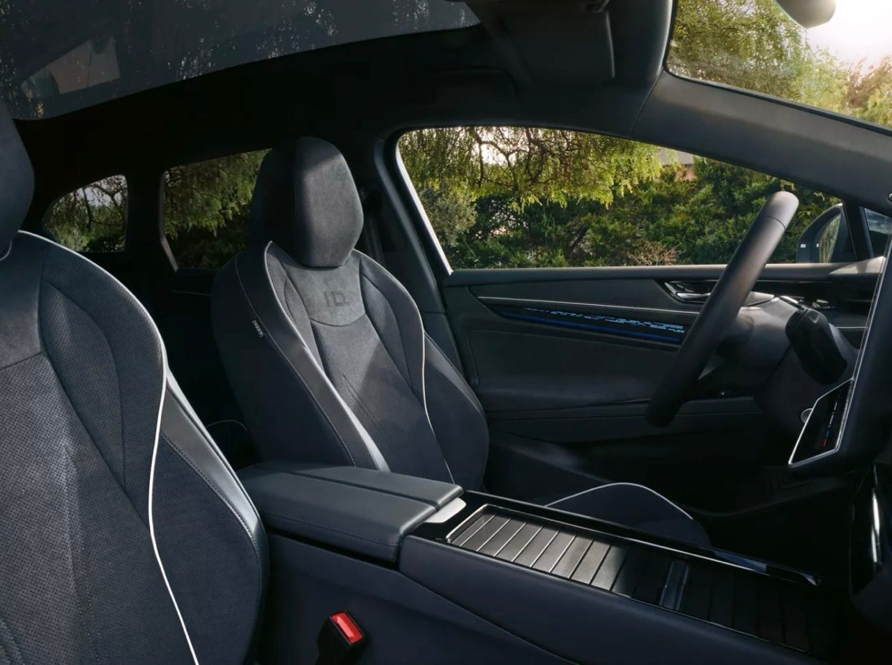 Modern car interior: dark seats with ID logo, center console, and steering wheel.