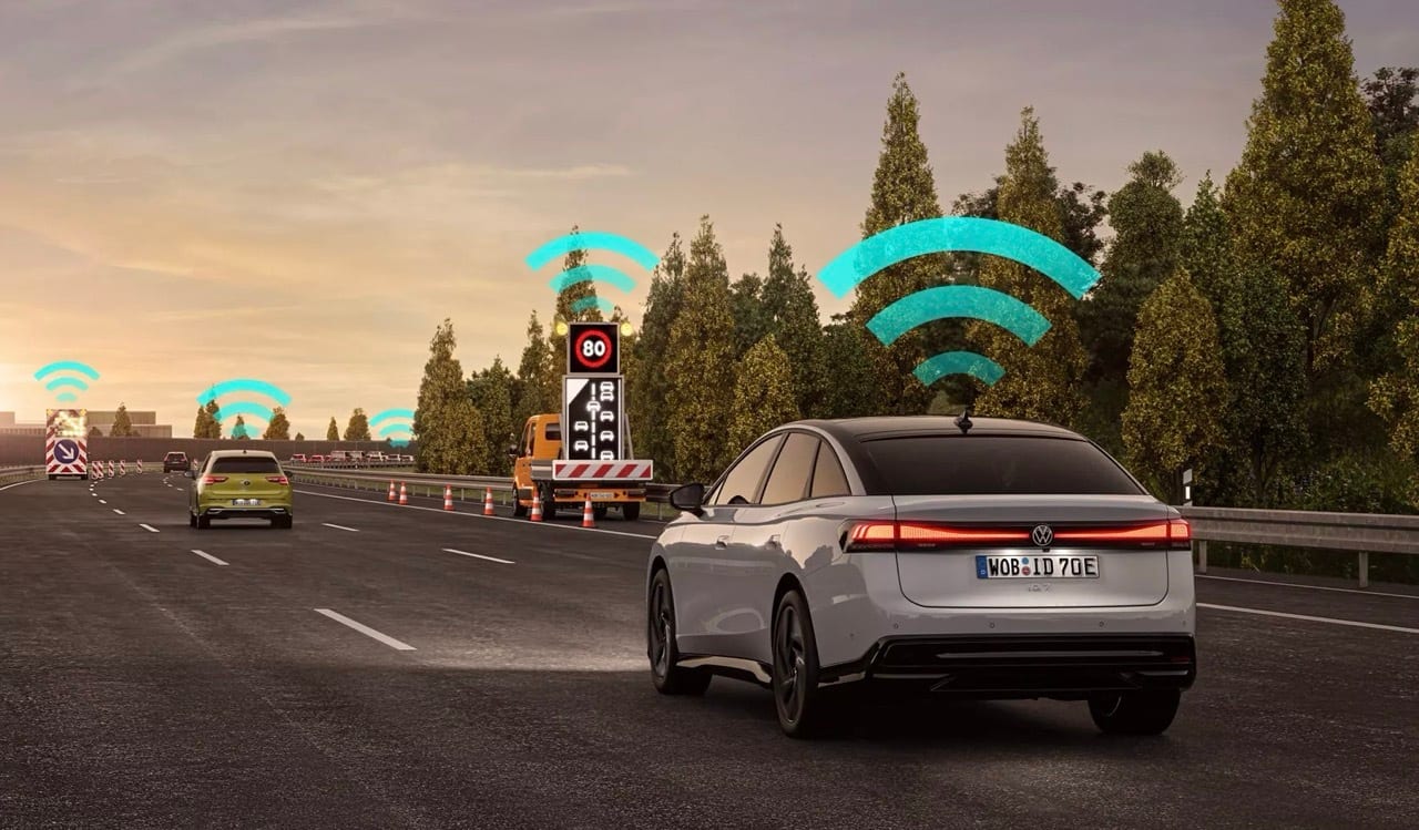 White car on highway, blue signals show vehicle-to-everything communication.