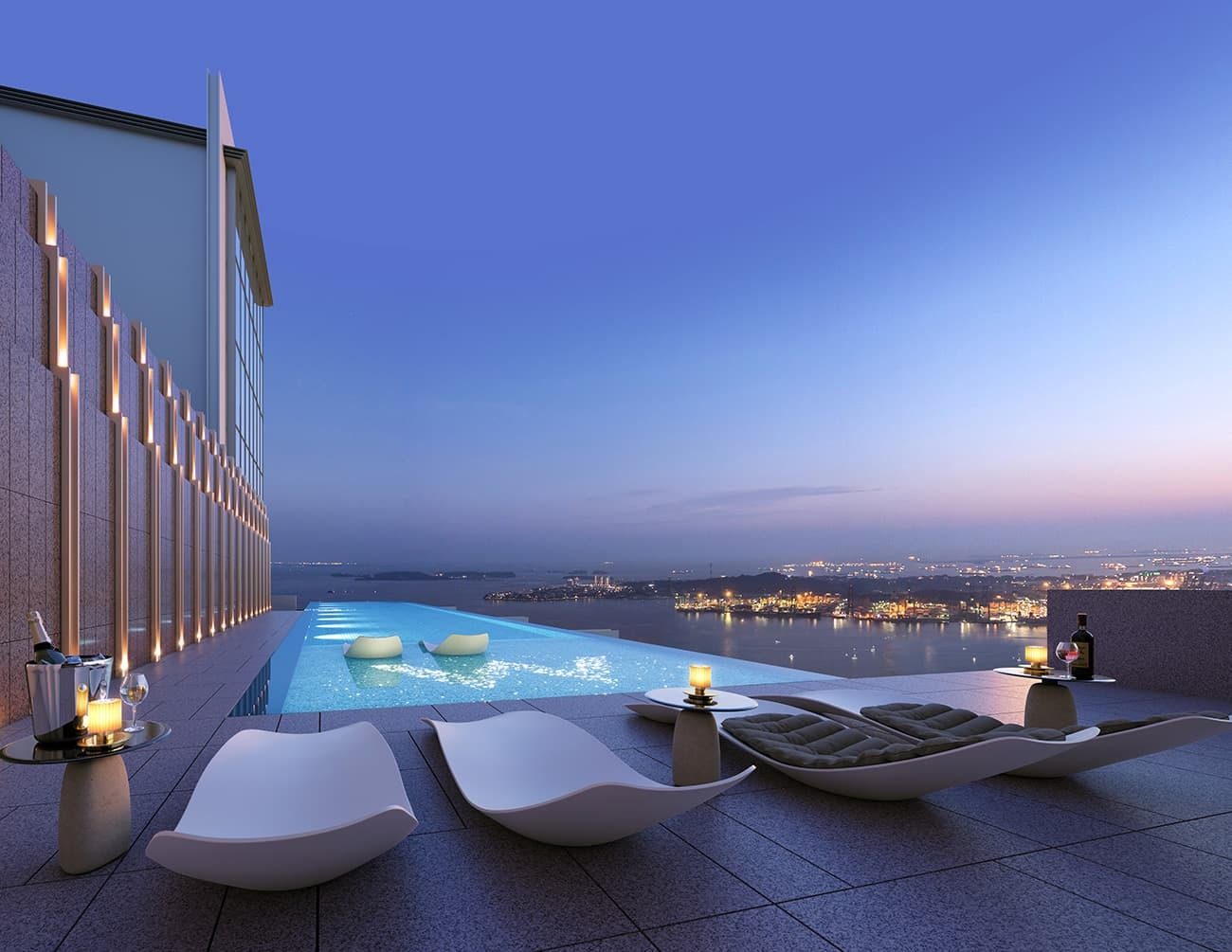 Rooftop infinity pool with lounge chairs and a city/sea view at dusk.