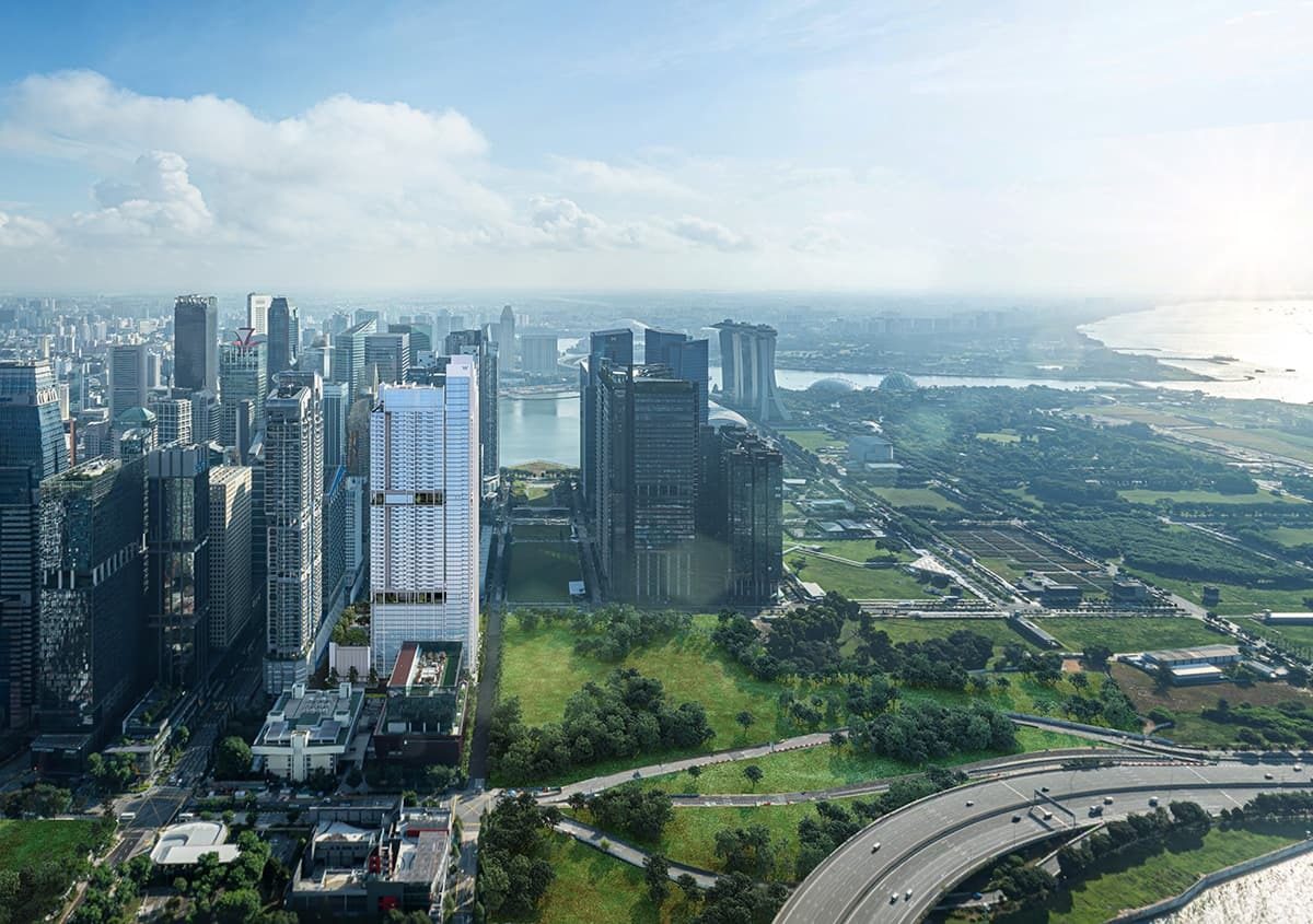 Aerial city skyline with a tall skyscraper, green parks, a bay, and Marina Bay Sands.