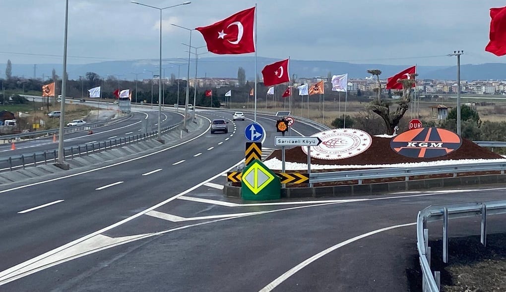 Mode of transport, Motor vehicle, Road surface, Automotive tire, Traffic sign, Sky, Asphalt, Cloud, Thoroughfare, Flag