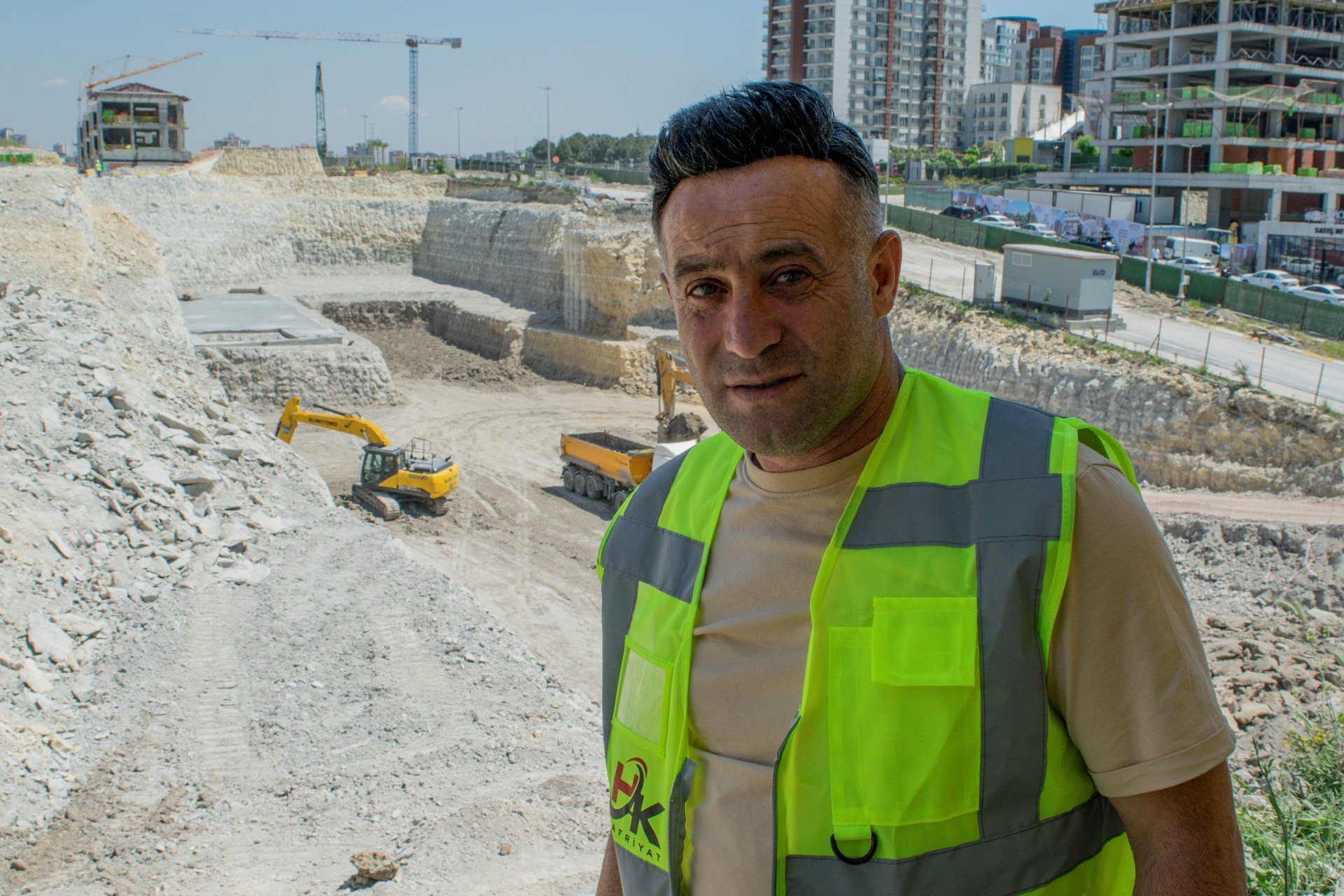 High-visibility clothing, Hard hat, Construction worker, Road surface, Sky, Workwear, Infrastructure, Asphalt, Sleeve, Building
