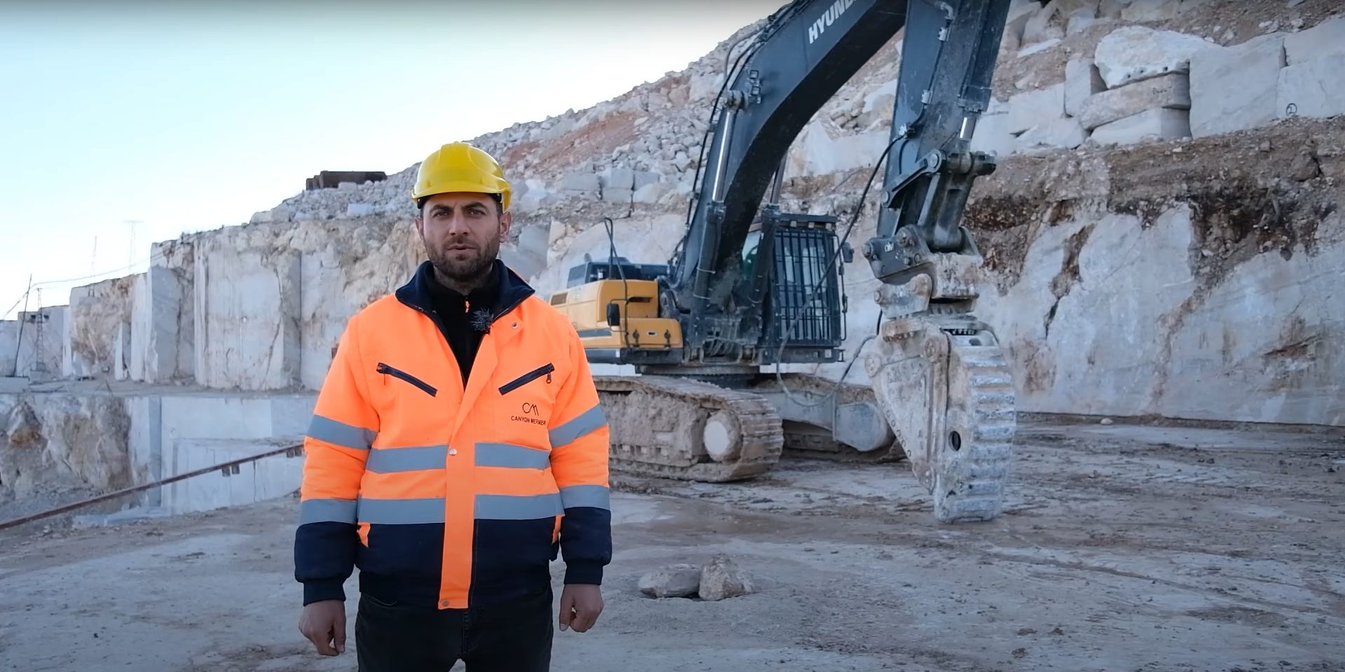 Hard hat, High-visibility clothing, Workwear, Sky, Sleeve, Asphalt, Helmet, Headgear, Vehicle, Vest