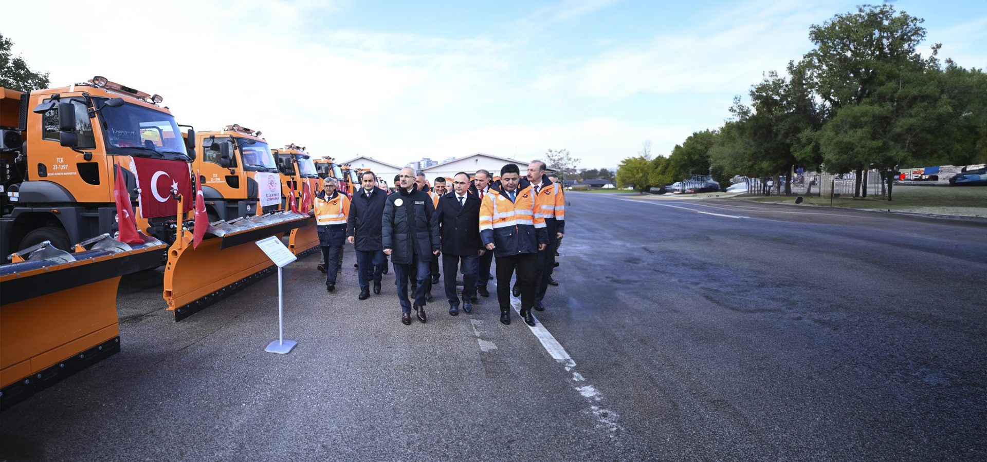 Motor vehicle, Road surface, Sky, Cloud, Workwear, Tire, Wheel, Tree, Asphalt