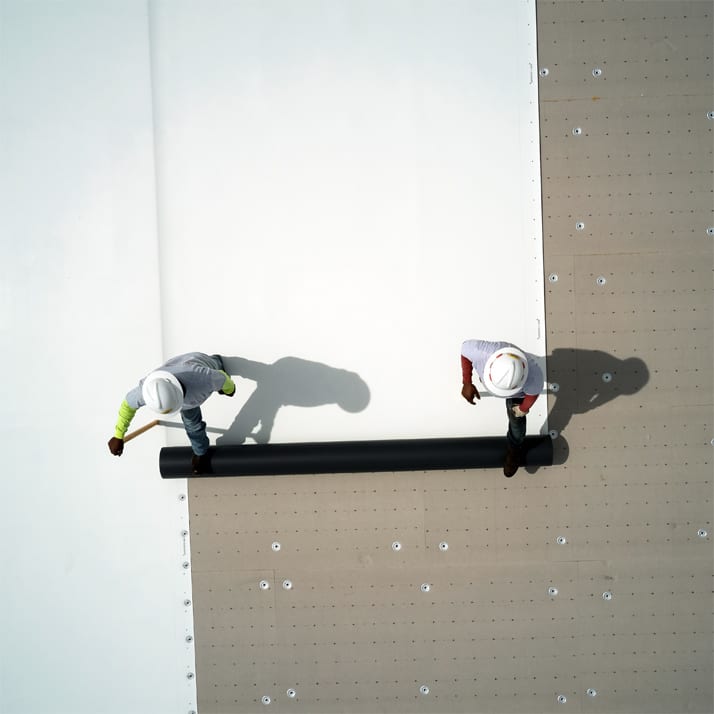 Drone image of two roofers installing ISO board.