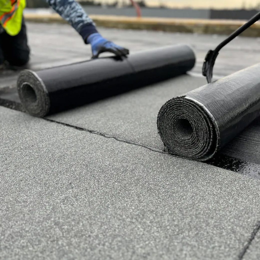 Closeup of SBS-modified bitumen membrane being applied to a commercial roof.