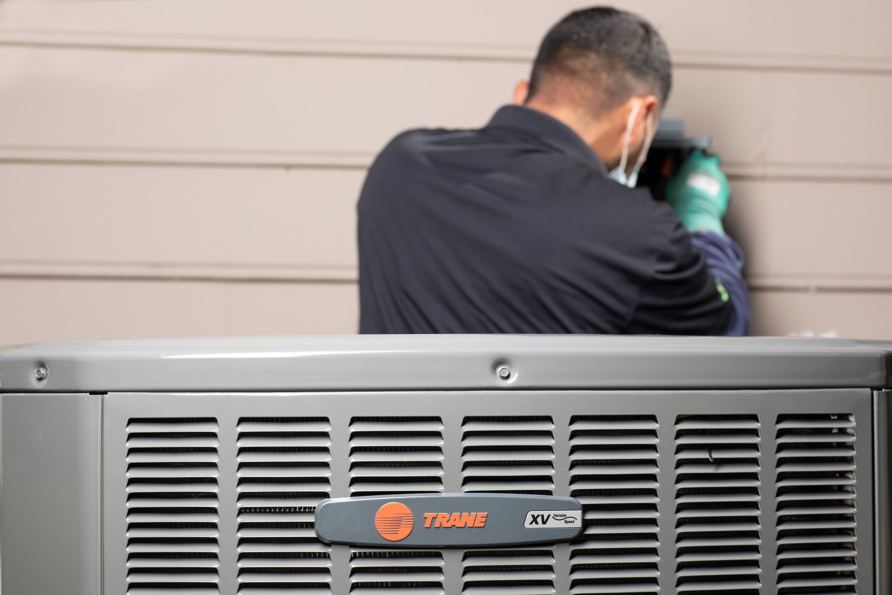 Professional installing HVAC equipment on a wall