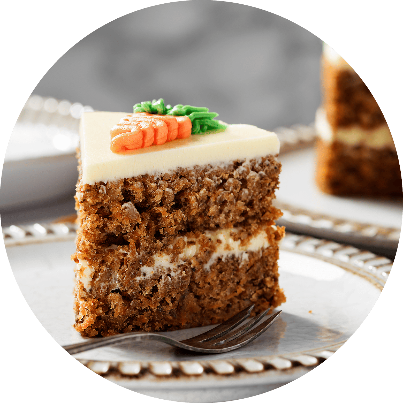 Slice of carrot cake with a fork on a fancy plate
