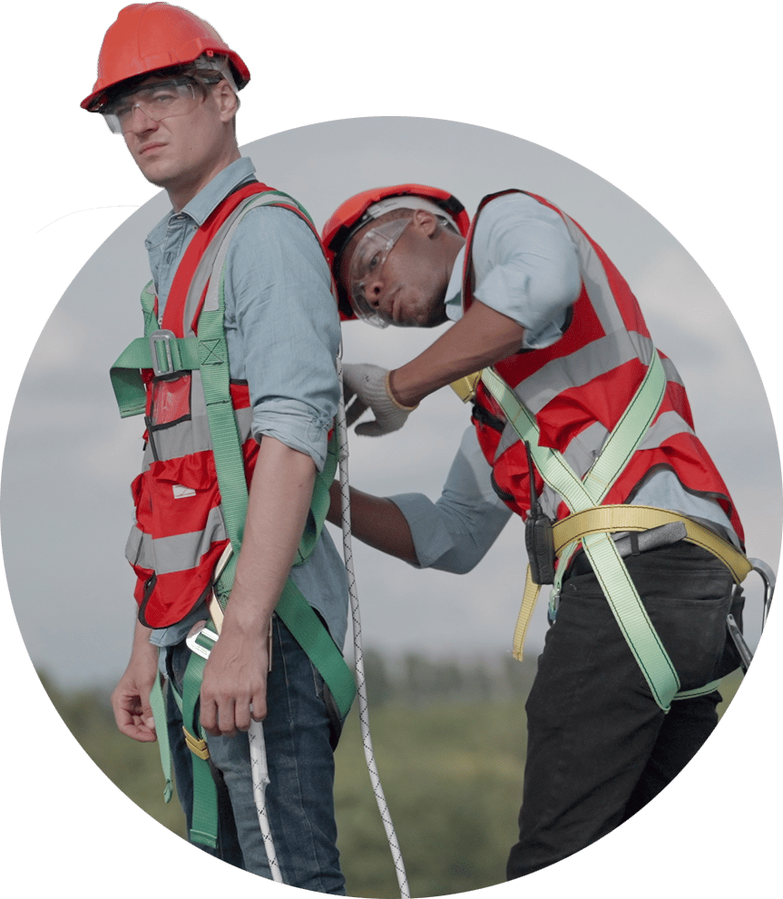 Two roofers putting on safety harnesses.