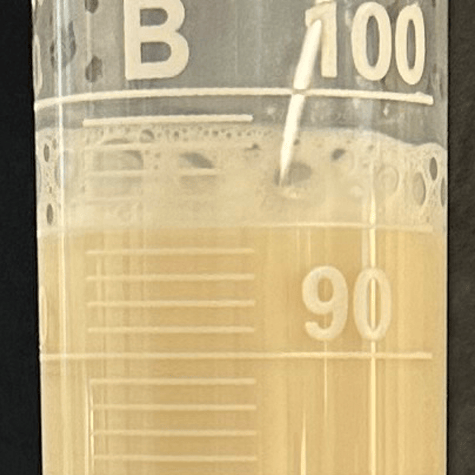Closeup of milk with large sparse bubbles containing no enzymes