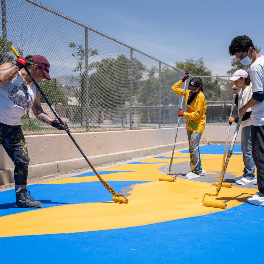 Community members applying solar-reflective coating to public hardscape.