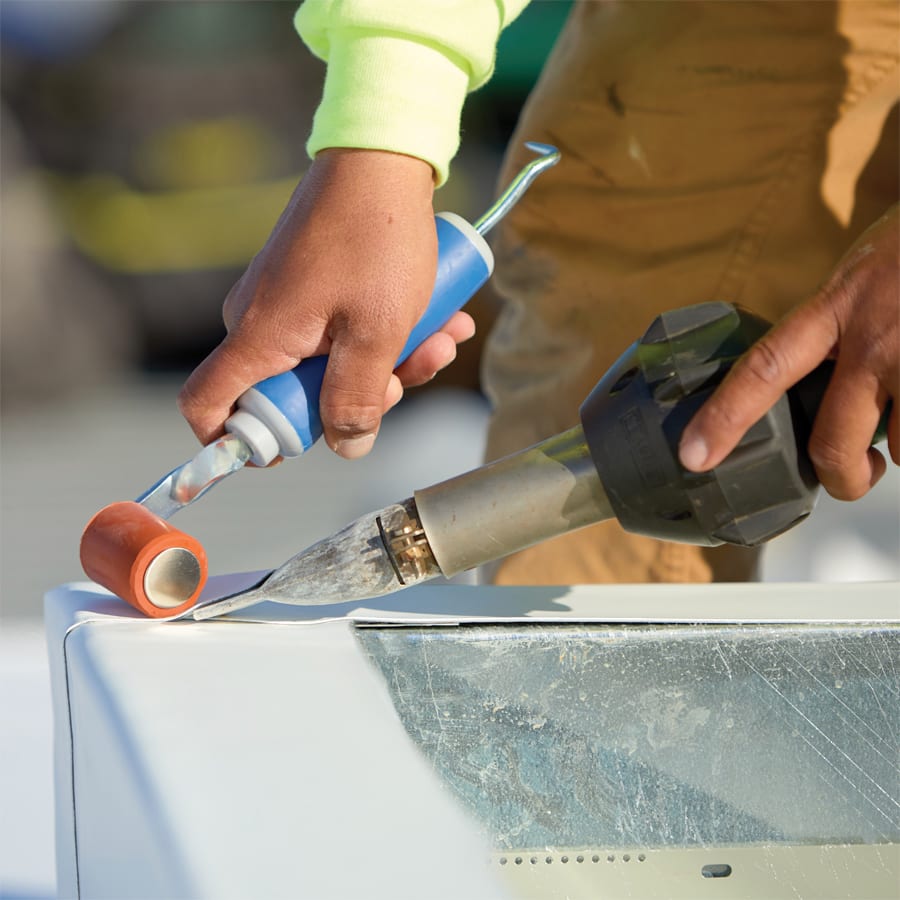 Closeup of roofer's hands applying air barrier