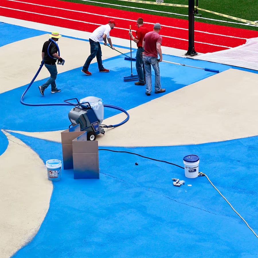 Workers with Streetbond apply a reflective paint to the basketball court at the SAE School in Mableton to reduce heat . Credit: Natrice Miller