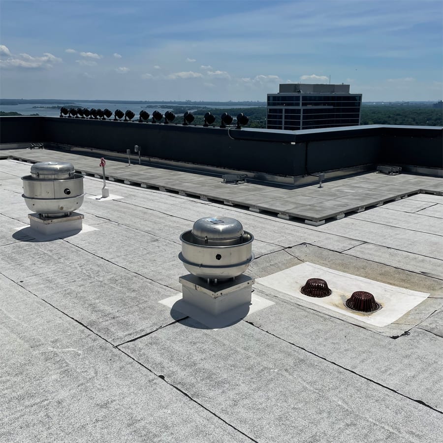 Detail of a durable asphaltic roof system under a blue sky.