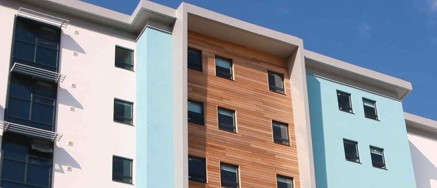closeup on a condominium exterior of multiple windows within wood cladding