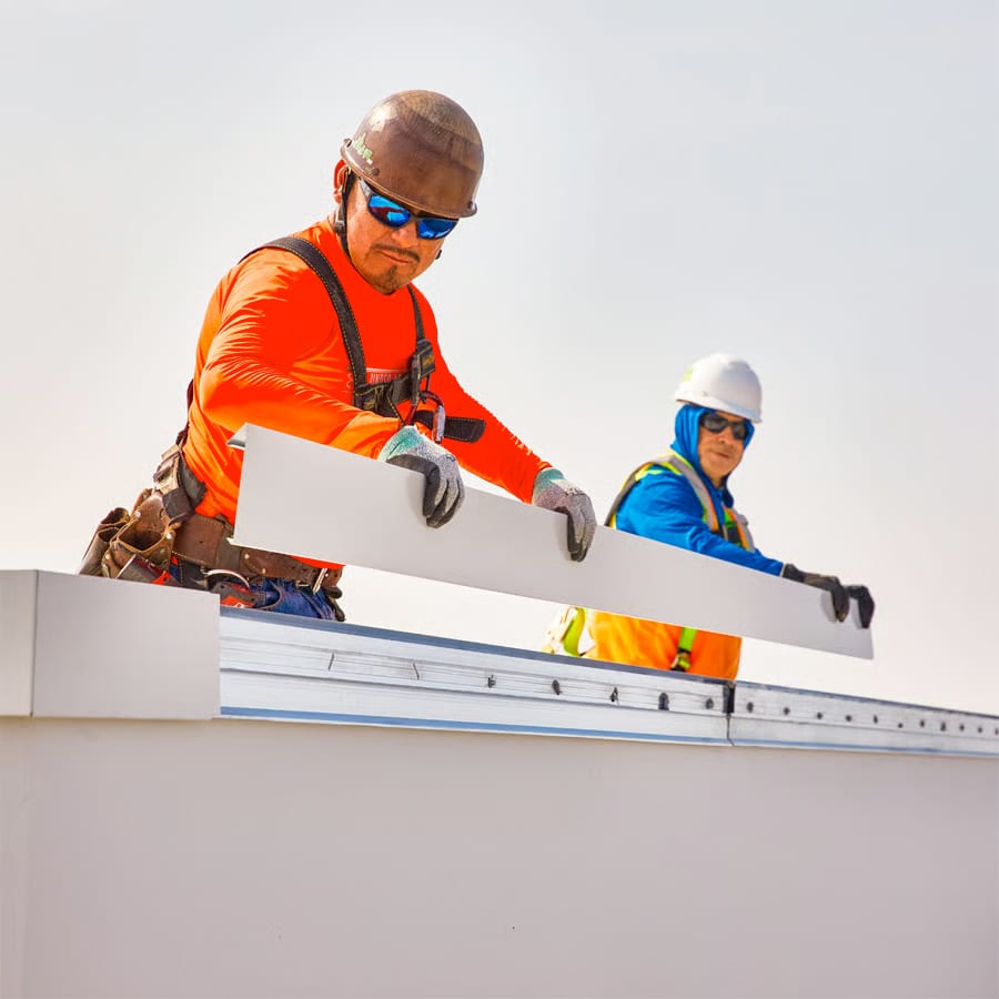 two skilled roofers installing a portion of edge metal
