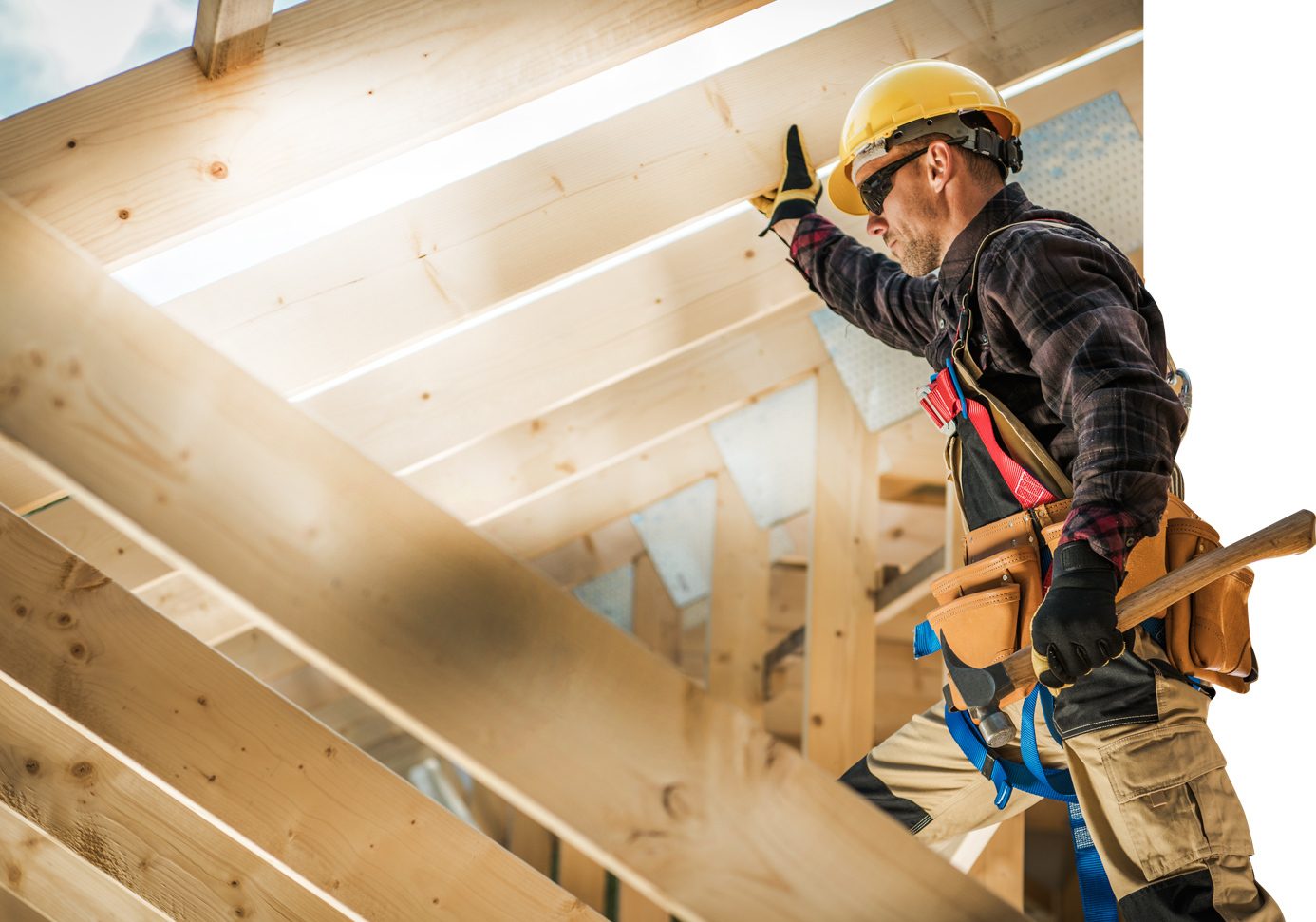 Closeup of a roofer in full construction gear in the beams of a roof construction