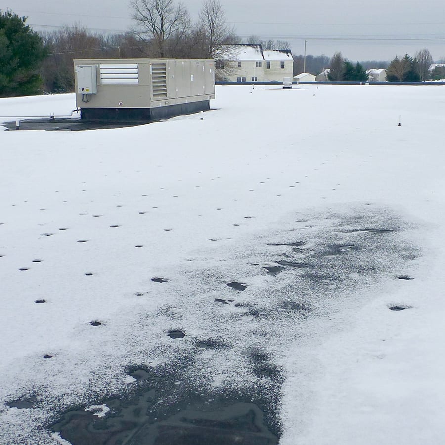 snow partially melting on a commercial roof