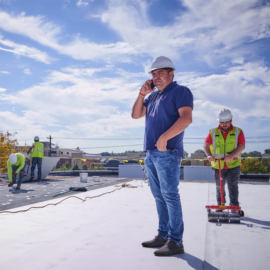 commercial roofers performing various roles on a job site