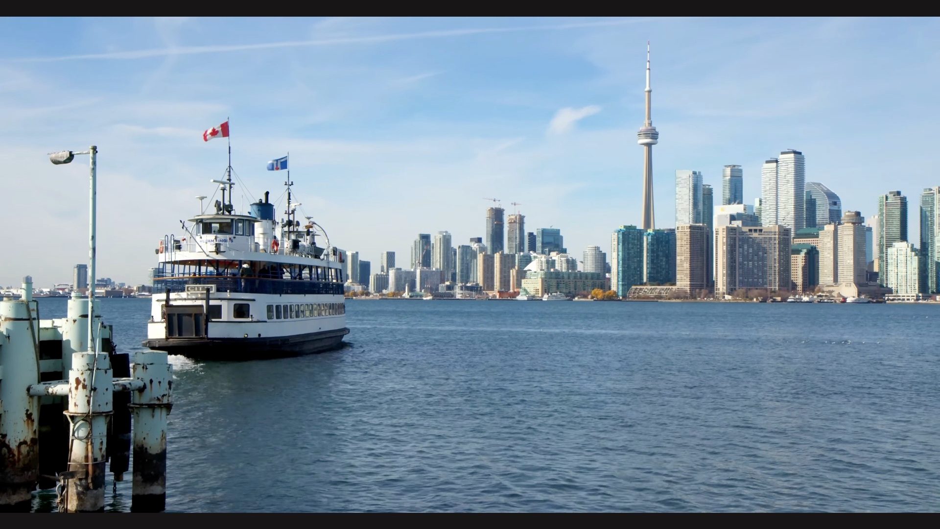 Toronto Skyline with lake and boat in foreground.