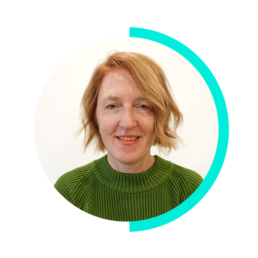 Smiling red-haired woman in a green sweater.